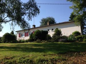 IlliersにあるDomaine de Montjouvinの赤窓と庭のある白い家