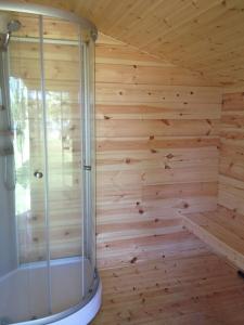a sauna with a shower in a wooden wall at Rundbergs Stugor in Kungsö