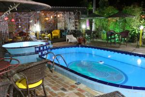 a swimming pool with a table and chairs next to it at Pousada das Laranjeiras in Antonina