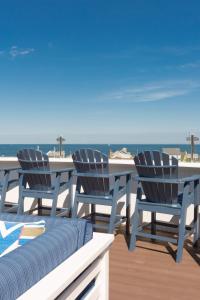 a table and chairs on a deck with the ocean at The Break Hotel in Narragansett