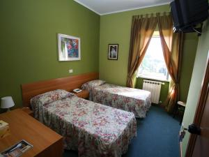 a hotel room with two beds and a window at Hotel Sutrium in Sutri