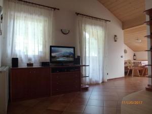 a living room with a television on a dresser at Dolomiti Appartamento Ivano in Predazzo