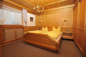 a bedroom with a large wooden bed with yellow pillows at Apart Piz Palü Kappl/Ischgl in Kappl