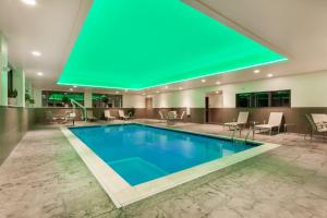 una piscina en el vestíbulo del hotel con un techo verde en Wingate by Wyndham Altoona Downtown/Medical Center, en Altoona