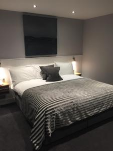 a bedroom with a large bed with a television on the wall at Carlton Hotel in Ilfracombe