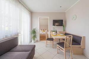 a living room with a table and a dining room at Quellenhof in Termeno