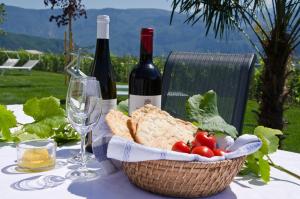een tafel met een mand met brood en wijnflessen bij Quellenhof in Termeno
