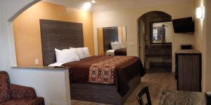 Habitación de hotel con cama y espejo en Regency Inn and Suites Galena Park, en Houston