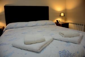 Una cama con dos toallas encima. en Mi Segunda Casa en Ushuaia