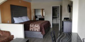 a hotel room with a bed and a couch at Regency Inn and Suites Galena Park in Houston
