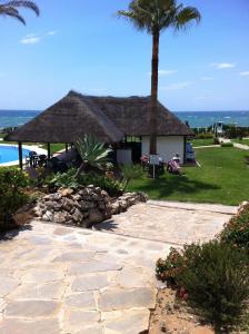a resort with a large straw hut with a palm tree at Mi Capricho in Sitio de Calahonda