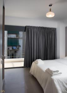 a bedroom with a bed and a large window at Elysium Boutique Apartments in Athens