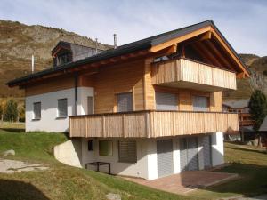 a house with wooden balconies on the side of it at Apartment Amore in Riederalp