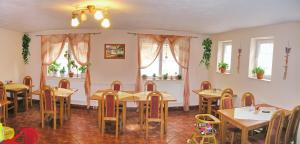 a restaurant with wooden tables and chairs and windows at Penzion Mirabel in Bešeňová