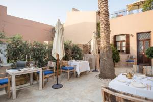 eine Terrasse mit Tischen und Sonnenschirmen in einem Resort in der Unterkunft La Maison Ottomane in Chania