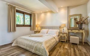 1 Schlafzimmer mit einem Bett, 2 Tischen und einem Spiegel in der Unterkunft Hotel Pilalidis in Pefkohori
