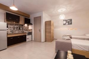 Spianada Collection of Studios & Apartments by Konnect في مدينة كورفو: غرفة نوم بسرير ومطبخ مع ثلاجة