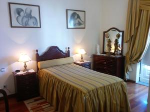 a bedroom with a bed with two dressers and a mirror at Hospedaria A Varanda in Alvito