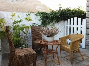 a table with chairs and a vase of flowers on a patio at Bilocale Pascoli in Santa Teresa Gallura