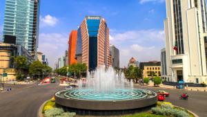 a fountain in the middle of a city with tall buildings at Barceló Mexico Reforma in Mexico City