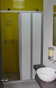 a bathroom with a sink and a glass shower at Explora Hostels in Bogotá