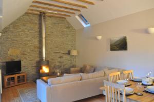a living room with a couch and a table at The Old Stables, Alltshellach Cottages in North Ballachulish