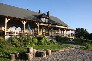 a large building with a lot of logs in front of it at Stajnia Wylągi in Kazimierz Dolny