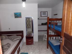 a bedroom with two bunk beds and a mirror at Pousada Paraíso in Ilha do Mel