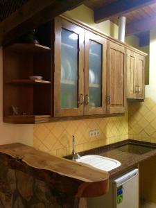 una cocina con fregadero y armarios de madera en Complejo Ribera de Salobre en Salobre