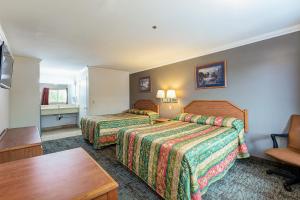 a hotel room with two beds and a table at Buena Vista Inn in Anaheim