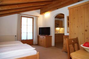 a bedroom with a bed and a flat screen tv at Ferienwohnungen Mueller in Oberstdorf