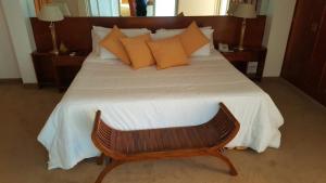 Un dormitorio con una cama grande con almohadas naranjas. en Ohasis Hotel Jujuy & Spa, en San Salvador de Jujuy