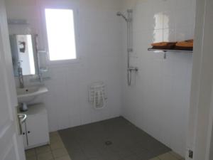 a white bathroom with a shower and a sink at Au Coeur Des Landes in Gaillères