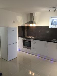 ヘイズにあるCosy 2 bedroom Apartment -Heathrow Airportのキッチン(白い冷蔵庫、コンロ付)