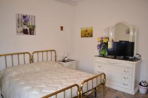 フォリーニョにあるIl Giardino del Galloのベッドルーム(ベッド1台、鏡、テレビ付)