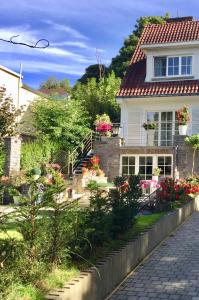 una casa bianca con fiori nel cortile anteriore di Studio swimming pool BXL a Dilbeek