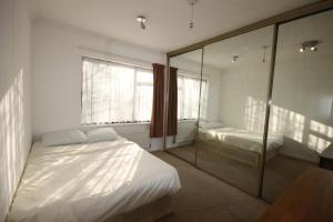 a bedroom with a bed and a mirror at Hill Crescent in London