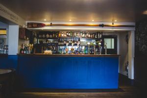 a blue bar in a restaurant with a blue wall at The Hero in Burnham Market