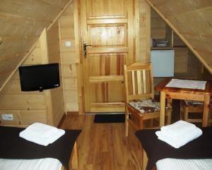 Pokój z 2 łóżkami, biurkiem i telewizorem w obiekcie Apartamenty U Lutnika Centrum Zakopane w Zakopanem