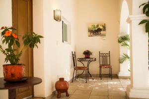 
a room with a table, chairs, and a vase of flowers at Hotel Casa San Miguel in San Miguel de Allende
