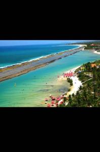 an aerial view of a beach with umbrellas at Marulhos resort Muro Alto in Porto De Galinhas