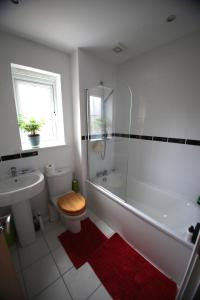 a bathroom with a toilet and a shower and a sink at Lymm House in Lymm