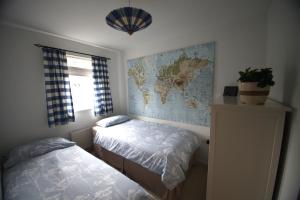 a bedroom with two beds and a map on the wall at Lymm House in Lymm