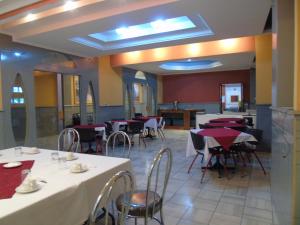 Un comedor con mesas y sillas en un restaurante. en El Centro Hotel, en Quetzaltenango