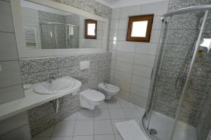 y baño con aseo, lavabo y ducha. en Hotel Kalemi 2 en Gjirokastër