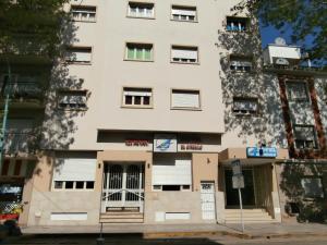 a tall white building with the doors open at Hotel El Circulo in Mar del Plata