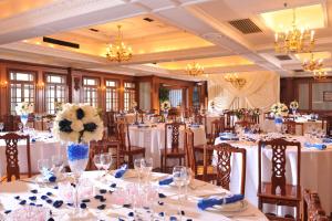 una sala banchetti con tavoli e sedie bianchi con fiori di Jing An Hotel a Shanghai