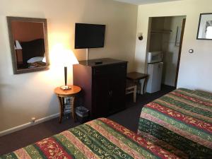 a hotel room with two beds and a mirror at Angola Motel in Angola-on-the-Lake