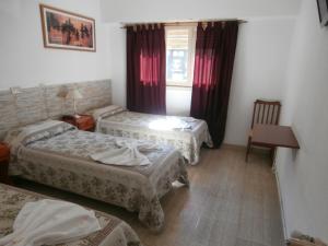 a hotel room with three beds and a window at Hotel El Circulo in Mar del Plata