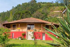 a house in a field with a red at Pousada das Flores in Gonçalves